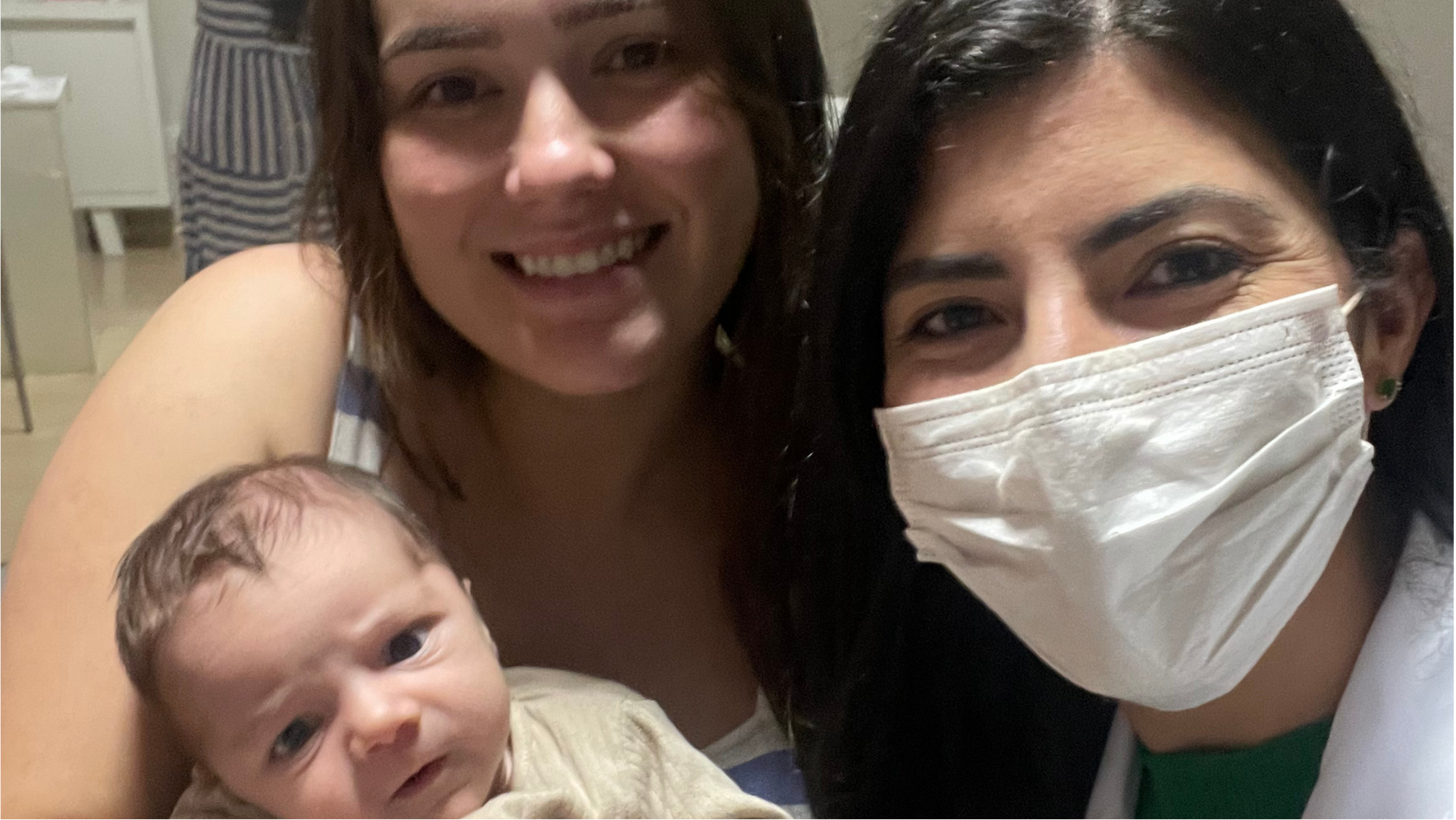 Mãe com bebê no colo ao lado de Isabella Andrade