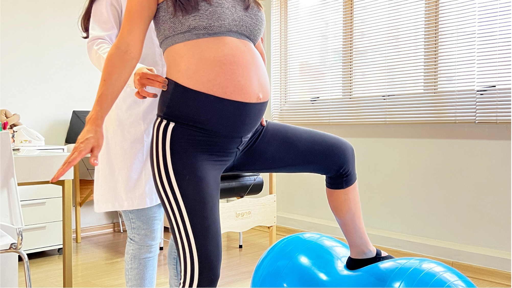 Exercício com bola azul e gestante em pé